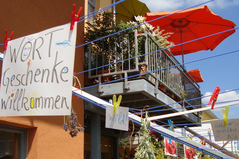 Wortgeschenke willkommen steht  auf einem Schild vor dem Balkon
