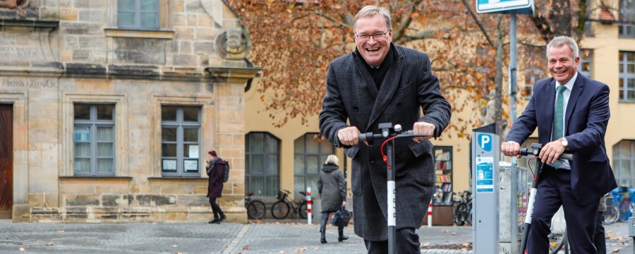 Oberbürgermeister Andreas Starke fährt mit dem E-Scooter durch Bamberg.