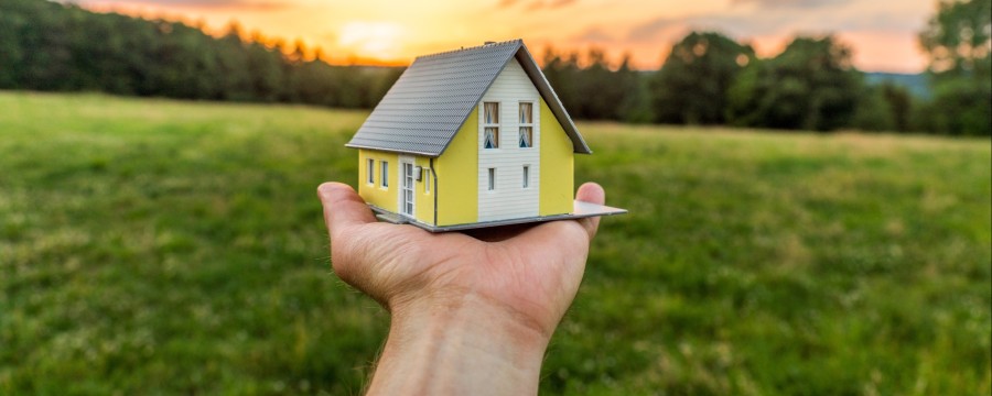 Bauland Haus in der Hand Symbolbild