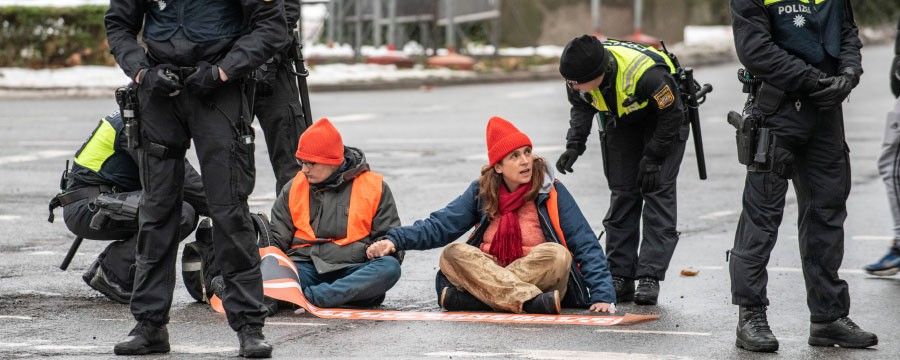Klimakleber Klimaaktivisten bei Sitzblockade und Polizei