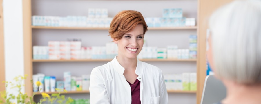 Frau kauft Medikamente, Apothekerin überreicht sie.