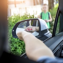 Mann bietet Jungen aus dem Auto Süßigkeiten an