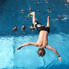 Junge springt im Freibad ins Wasser